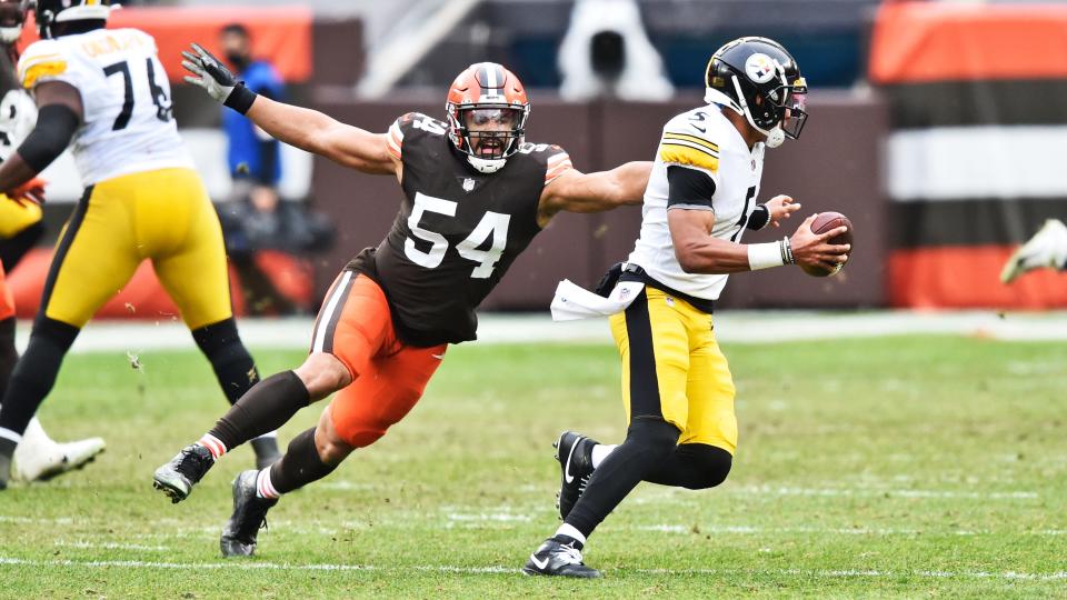 Cleveland Browns defensive end Olivier Vernon (54) tries to tackle Pittsburgh Steelers quarterback Joshua Dobbs (5) during the second half of an NFL football game, Sunday, Jan. 3, 2021, in Cleveland. (AP Photo/David Richard)