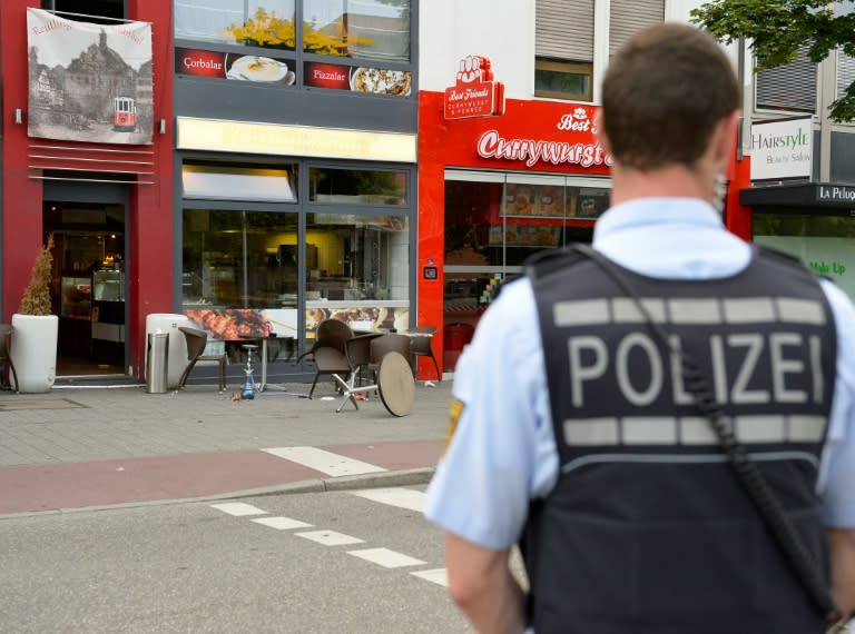 A police officer stands in front of a restaurant in Reutlingen, southwestern Germany, on July 24, 2016 where a Syrian asylum-seeker killed a woman and injured two people with a machete