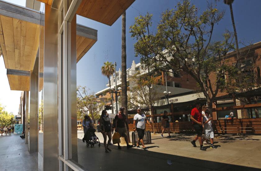 SANTA MONICA, CA - AUGUST 03: Store window reflections as pedestrians of all ages with and without masks walk the Third Street Promenade in Santa Monica Tuesday, August 3, 2021 as Californians and visitors react to the grey space we're in with COVID, lax restrictions and breakthrough cases. Third Street Promenade on Tuesday, Aug. 3, 2021 in Santa Monica, CA. (Al Seib / Los Angeles Times).