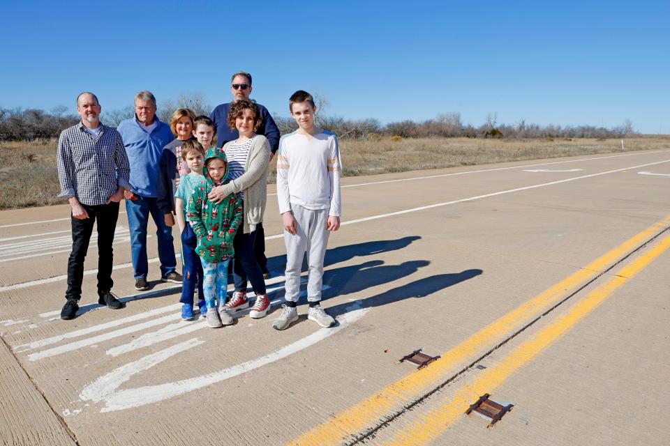 From left, James King, Scott and Kim Shelton, Gary Reimer, in back, with Kristen Bruce and her children, Peter, 11, left, David, 9, Lucy, 7, and Jonah, 12, pose for a photo Tuesday, Jan. 30, 2024, at a former turnpike ramp along SW 15 in Oklahoma City. The former turnpike ramp will be one of the entrances to the proposed Sunset Amphitheater to be developed by Colorado Springs-based Notes Live.