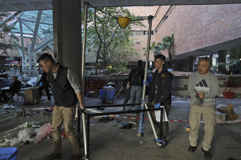 Police officers carry a home made catapult to the evidence processing point in the Polytechnic University campus in Hong Kong, Thursday, Nov. 28, 2019. Police safety teams Thursday began clearing a university that was a flashpoint for clashes with protesters, and an officer said any holdouts still hiding inside would not be immediately arrested. (AP Photo/Ng Han Guan)