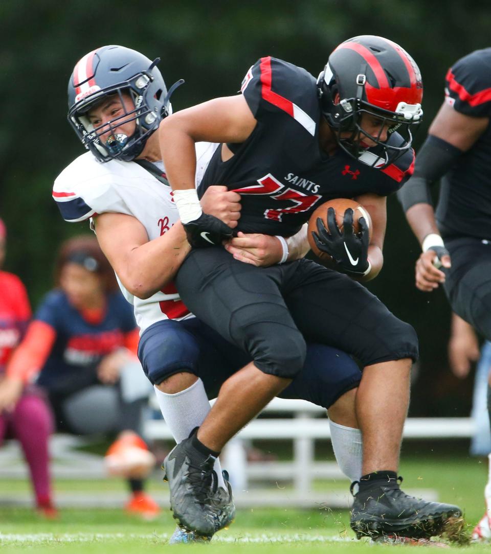 First State Military's Jarrett Waltz grabs St. Andrew's Reinaldo Quinones in the second quarter of St. Andrew's 34-13 win at home, Friday, Oct. 6, 2023.