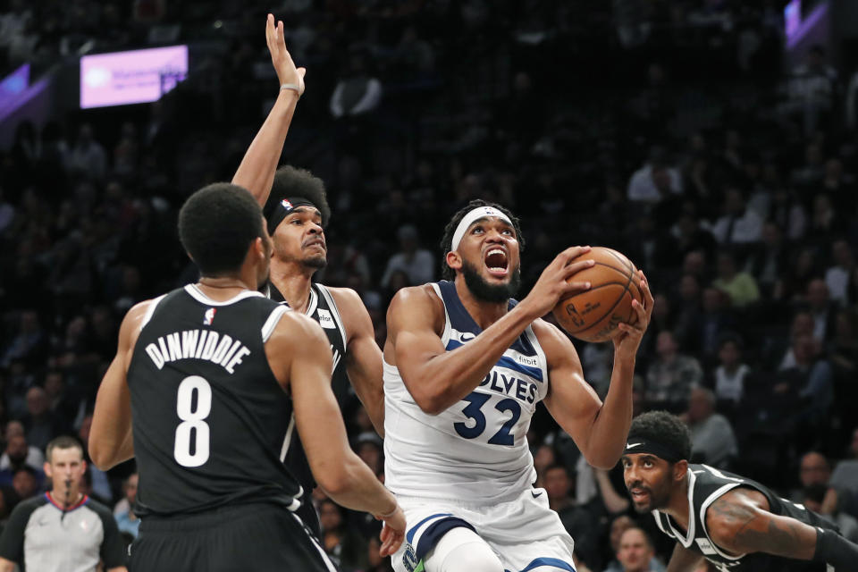 Brooklyn Nets guard Spencer Dinwiddie (8) and center Jarrett Allen, center, defend against Minnesota Timberwolves center Karl-Anthony Towns (32) as Towns goes up for a layup during the first half of an NBA basketball game Wednesday, Oct. 23, 2019, in New York. (AP Photo/Kathy Willens)