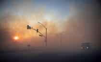 Early morning smoke casts an eerie orange cast along Irvine Blvd. near Alton on Tuesday, Oct. 27, 2020, because of (Mindy Schauer/The Orange County Register via AP)