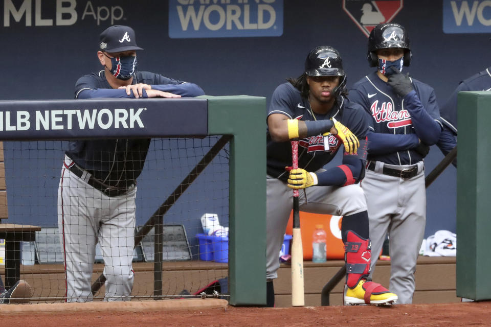 Atlanta Braves manager Brian Snitker, left, and right fielder Ronald Acuna watch after the Braves ended a scoring opportunity scoring no runs during the second inning against the Los Angeles Dodgers in Game 6 of baseball’s National League Championship Series, Saturday, Oct. 17, 2020, in Arlington, Texas. (Curtis Compton/Atlanta Journal-Constitution via AP)