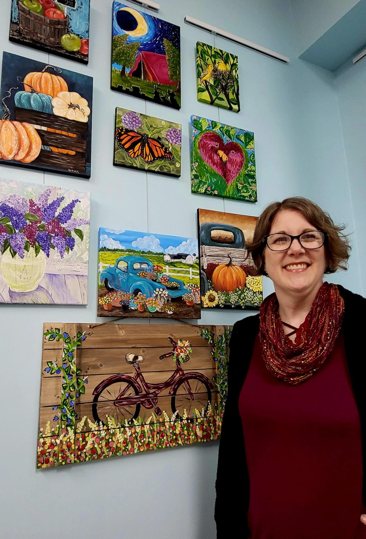 Rose Gottler, of the Painted Toad, stands with work examples she shares with clients on Thursday, March 16, 2023, at a new spaces she shares with New Century Art Gallery at 312 S. Water St.