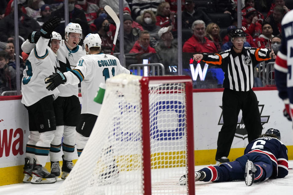 San Jose Sharks defenseman Nicolas Meloche, center, celebrates his goal against the Washington Capitals with teammates Matt Nieto, left, and Andrew Cogliano during the second period of an NHL hockey game, Wednesday, Jan. 26, 2022, in Washington. At right is Washington Capitals defenseman Michal Kempny. (AP Photo/Evan Vucci)