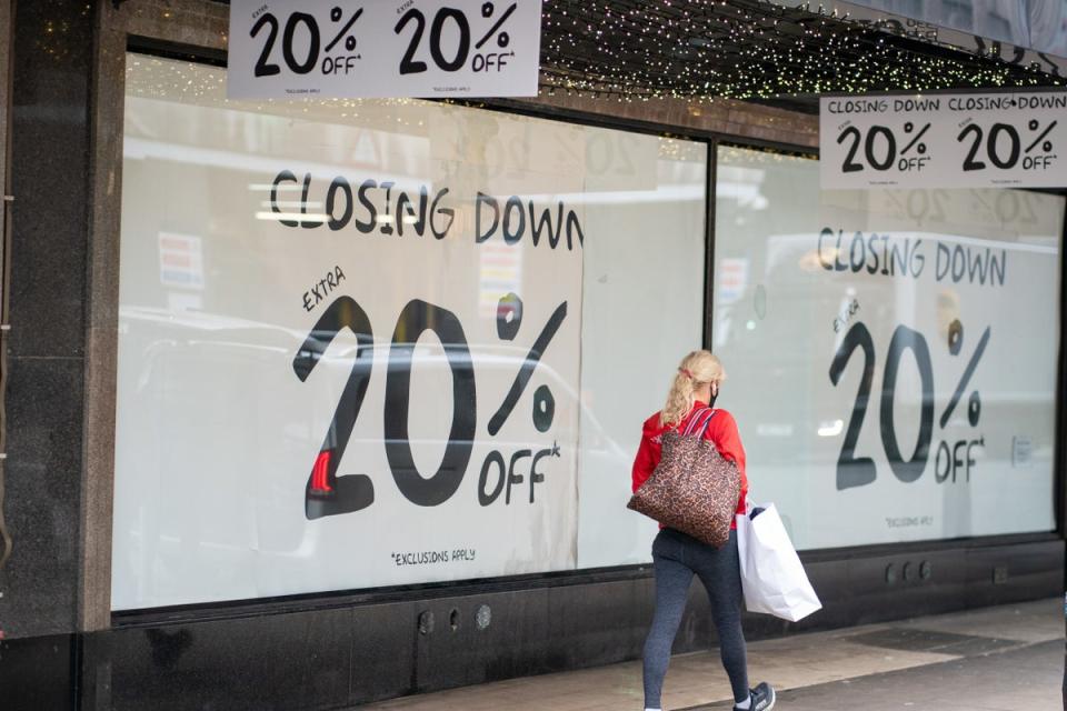 A shopper passes a closing down sale sign  (PA) (PA Archive)