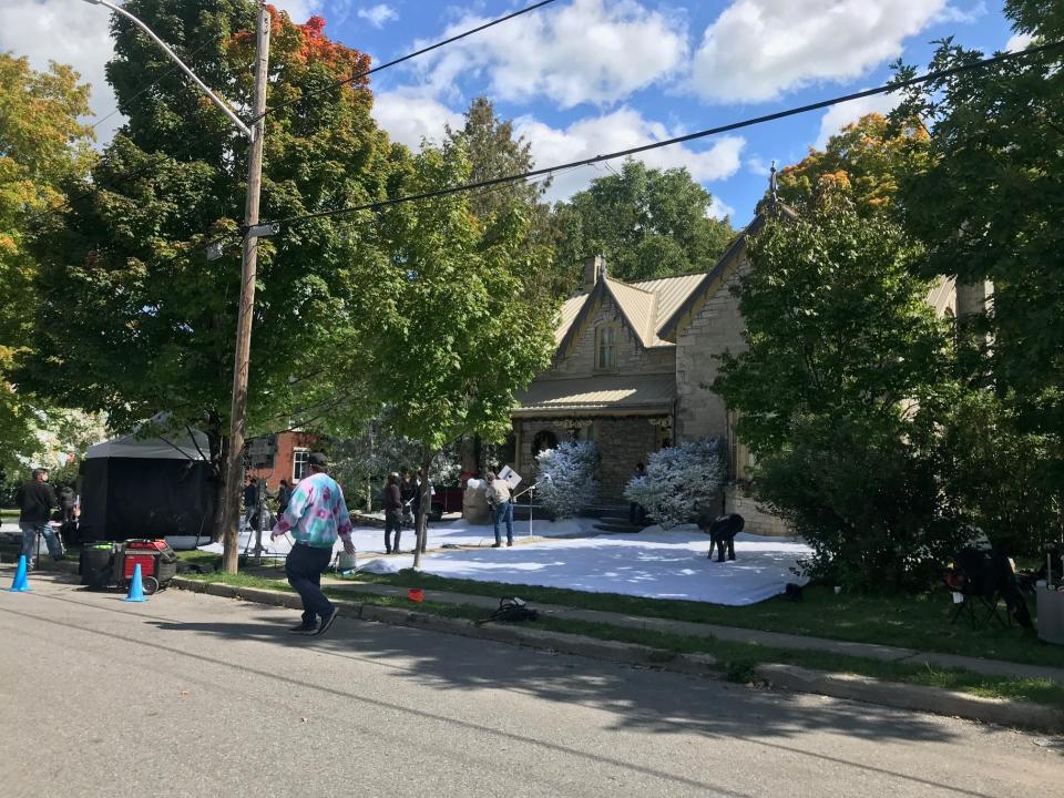 House with fake snow laid in front of it to prepare to shoot a Christmas scene in summertime
