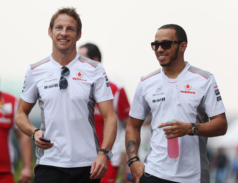 jenson button and lewis hamilton walk through the formula 1 paddock wearing mclaren team kit in 2012