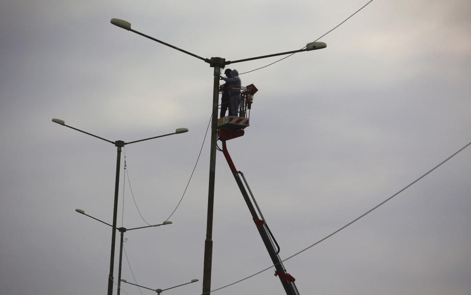 Workers try to restore the electricity supply on a street lamp in the town of Pernik, Bulgaria, Thursday, April 21, 2022. Bulgaria, a nation of 6.5 million people, once was among Moscow’s closest allies during the Soviet era. Now a NATO and EU member, it is still heavily dependent on Russian energy. Its only oil refinery is owned by Russia’s Lukoil, supplying nearly two-thirds of the country’s energy needs. (AP Photo/Valentina Petrova)