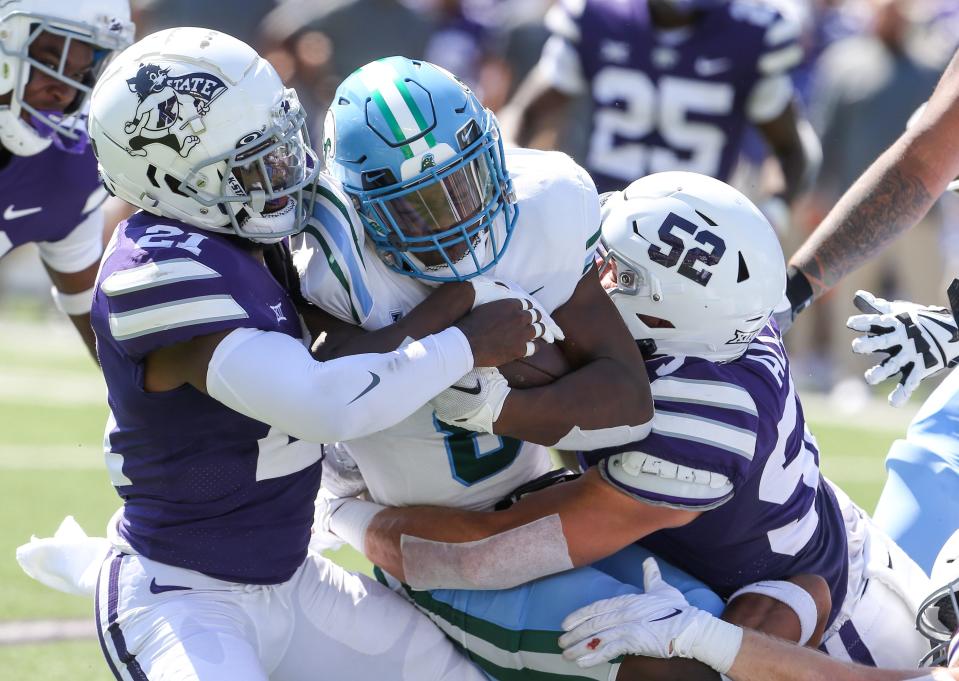 Tulane running back Iverson Celestine (8) is tackled by Kansas State Wildcats safety Drake Cheatum (21) and linebacker Nick Allen (52) during the first quarter Saturday at Bill Snyder Family Football Stadium.