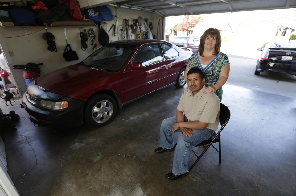 In this photo taken Monday, March 24, 2014, Martin Del Agua and his wife, Julie are seen in the garage of their home in Sacramento, Calif. Martin Del Agua faced deportation when he was arrested after neighbor complained that he was playing his music to loud in his garage.(AP Photo/Rich Pedroncelli)