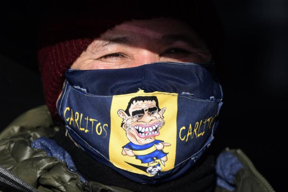 A man wearing a mask with a cartoon Carlos Tévez in Buenos Aires.