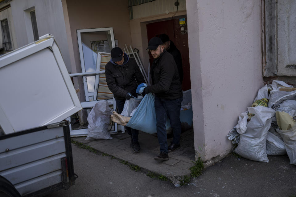 Morgue workers carry the body of a woman that died after a Russian attack at a residential area in Uman, central Ukraine, Friday, April 28, 2023. (AP Photo/Bernat Armangue)