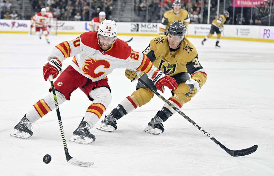 Calgary Flames center Blake Coleman (20) and Vegas Golden Knights defenseman Brayden McNabb (3) chase the puck during the third period of an NHL hockey game Thursday, Feb. 23, 2023, in Las Vegas. (AP Photo/David Becker)