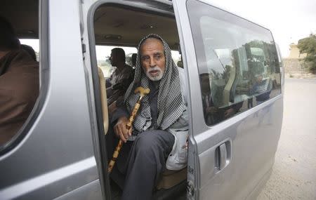 A Palestinian man returning to Gaza looks out as he sits in a vehicle at the Rafah border crossing between Egypt and southern Gaza Strip November 26, 2014. REUTERS/Ibraheem Abu Mustafa