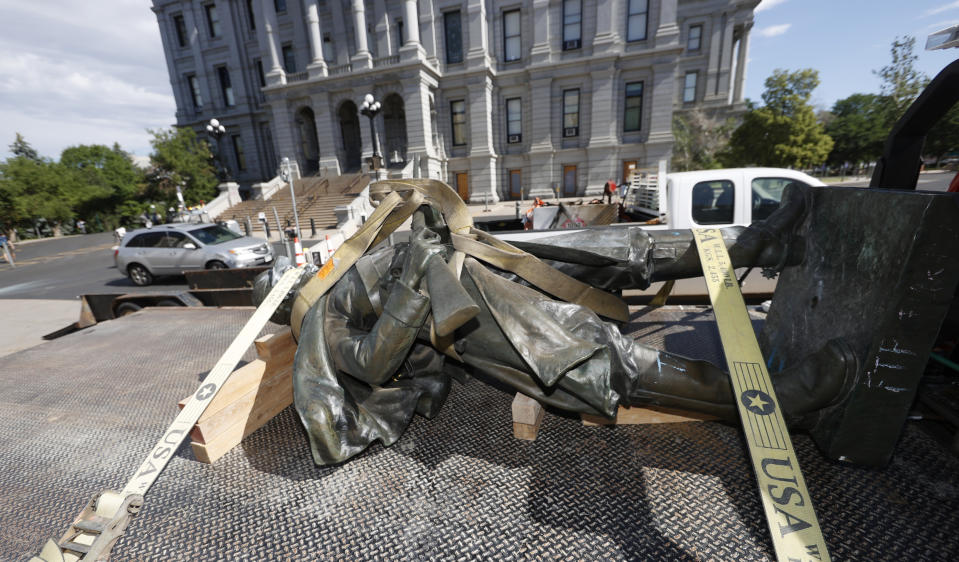 FILE - In this June 25, 2020 file photo, the Civil War Monument statue is shown loaded on the back of a flatbed truck after it was toppled from its pedestal in front of the State Capitol in Denver. The monument, which portrays a Union soldier and was erected in 1909, was targeted during demonstrations over the death of George Floyd before the statue was pulled down by four individuals. On Thursday, Feb. 25, 2021, Colorado lawmakers will discuss what to put in place of the statue. (AP Photo/David Zalubowski, File)