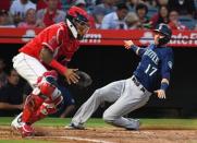 Jul 11, 2018; Anaheim, CA, USA; Seattle Mariners right fielder Mitch Haniger (17) scores against Los Angeles Angels catcher Martin Maldonado (12) on a two RBI single by Seattle designated hitter Nelson Cruz (not pictured) in the fourth inning at Angel Stadium of Anaheim. Mandatory Credit: Jayne Kamin-Oncea-USA TODAY Sports