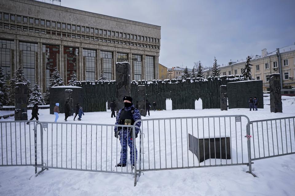 A police officer guards an area as people walk to lay flowers paying their last respect to Alexei Navalny at the at the Wall of Sorrow memorial to victims of political repression, in Moscow, Russia, on Sunday, Feb. 18, 2024. Russians across the vast country streamed to ad-hoc memorials with flowers and candles to pay tribute to Alexei Navalny, the most famous Russian opposition leader and the Kremlin's fiercest critic. Russian officials reported that Navalny, 47, died in prison on Friday. (AP Photo/Alexander Zemlianichenko)