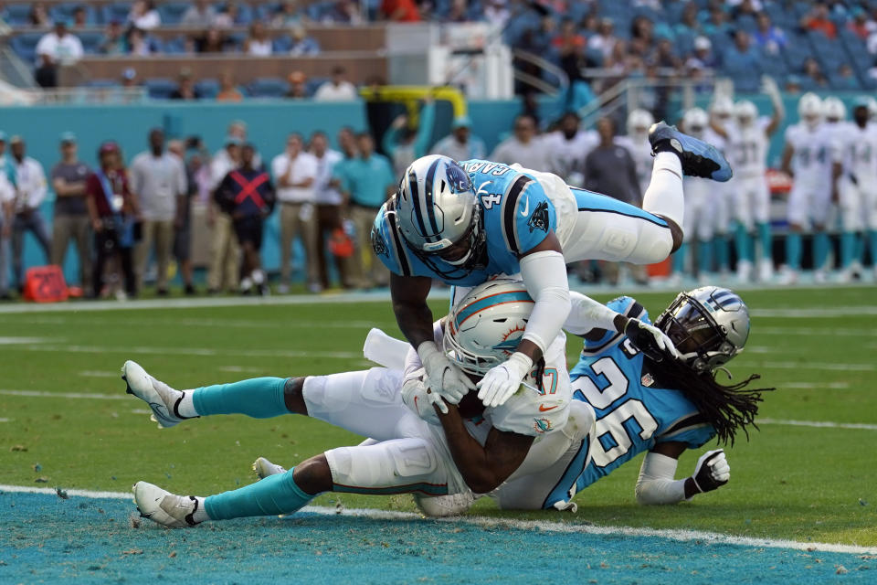 Miami Dolphins wide receiver Jaylen Waddle (17) scores a touchdown past Carolina Panthers cornerback Donte Jackson (26), and middle linebacker Jermaine Carter Jr. (4) during the first half of an NFL football game, Sunday, Nov. 28, 2021, in Miami Gardens, Fla. (AP Photo/Lynne Sladky)