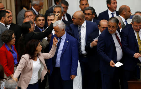 Pro-Kurdish opposition Peoples' Democratic Party (HDP) MPs react to Turkey's ruling AK Party (AKP) as they vote in favor of an article of constitutional change that could see pro-Kurdish and other lawmakers prosecuted at the Turkish parliament in Ankara, Turkey, May 20, 2016. REUTERS/Umit Bektas TPX IMAGES OF THE DAY