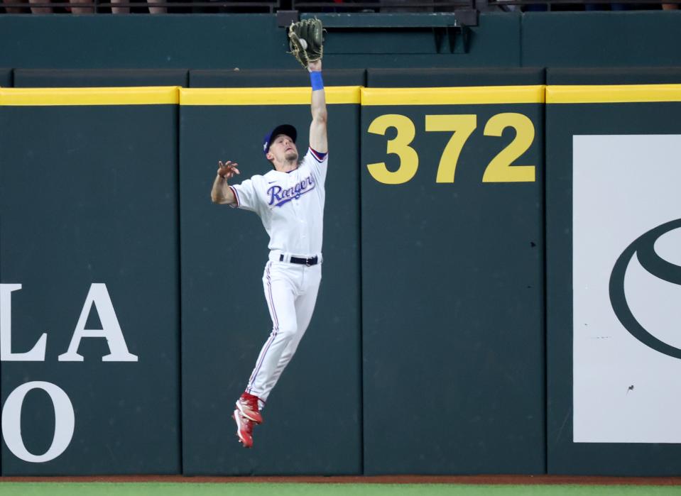 Rangers outfielder Evan Carter makes a catch during the seventh inning of Game 5 of the ALCS against the Astros at Globe Life Field in Arlington, Texas on Oct. 20, 2023.