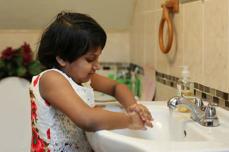 Nabiha A Chowdhury, 7, demonstrates her process for removing potential lead from her hands by washing them at her home in Buffalo, New York March 30, 2017. REUTERS/Lindsay DeDario