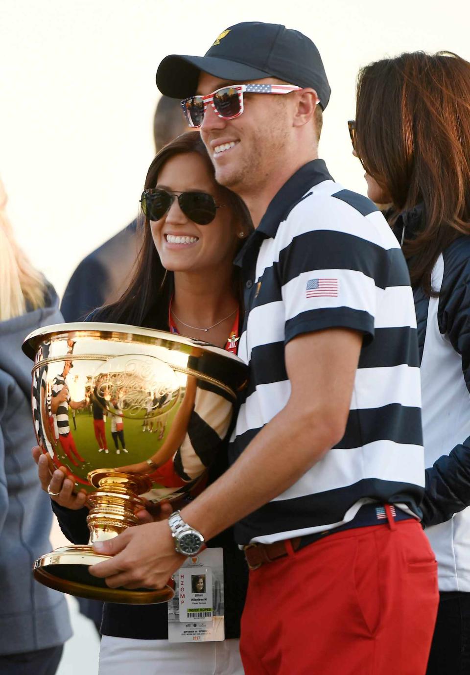 Justin Thomas of the U.S. Team and girlfriend Jillian Wisniewski celebrate with the trophy after the U.S. Team defeated the International Team 19 to 11 in the Presidents Cup at Liberty National Golf Club on October 1, 2017, in Jersey City, New Jersey