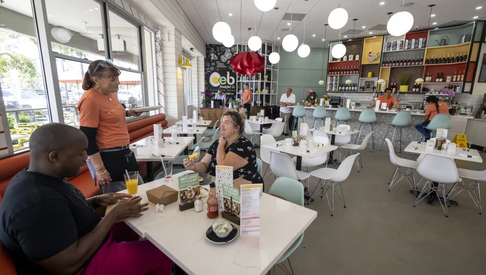 NEWPORT BEACH, CA - May 04: A waitress talks with customers at OEB Breakfast Co. in Newport Beach, CA on Wednesday, May 4, 2022. This is the second OEB in the U.S. after one in Scottsdale, Arizona. The menu is by classically trained chef and OEB founder Mauro Martina. (Photo by Paul Bersebach/MediaNews Group/Orange County Register via Getty Images)