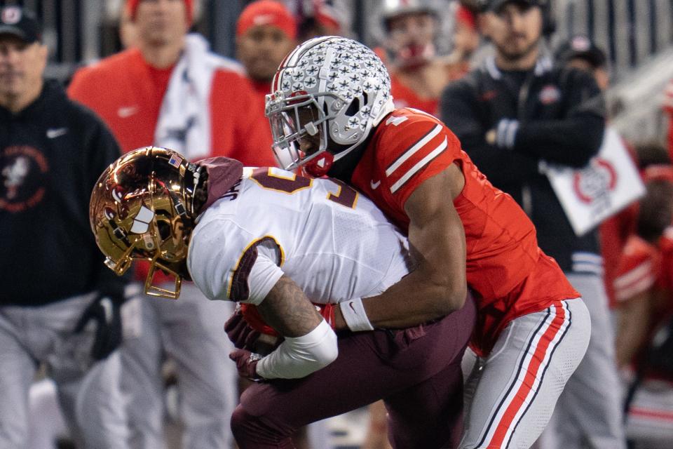 Nov 18, 2023; Columbus, Ohio, USA; 
Ohio State Buckeyes cornerback Davison Igbinosun (1) tackles Minnesota Golden Gophers wide receiver Daniel Jackson (9) during the second half of their game on Saturday, Nov. 18, 2023 at Ohio Stadium.