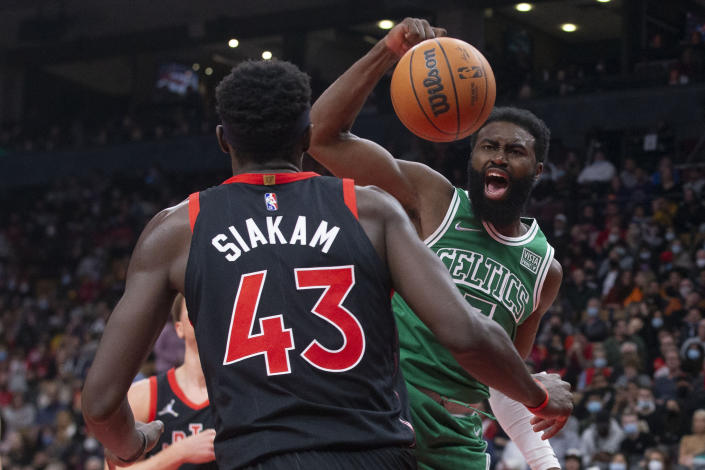 Boston Celtics' Jaylen Brown, right, scores as Toronto Raptors' Pascal Siakam looks on during first-half NBA basketball game action in Toronto, Sunday, Nov. 28, 2021. (Chris Young/The Canadian Press via AP)