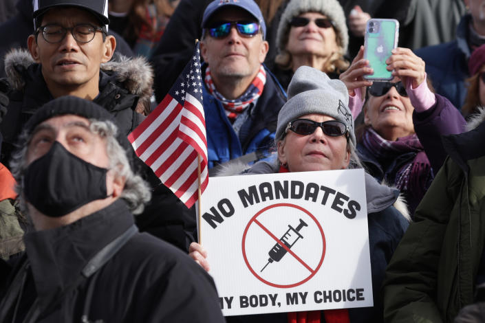 An anti-vaccination activist at a rally holds a sign that reads: No mandates. My body, my choice.