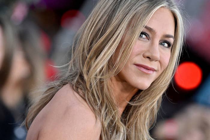 Close-up of Jennifer Aniston wearing a stylish outfit and smiling softly