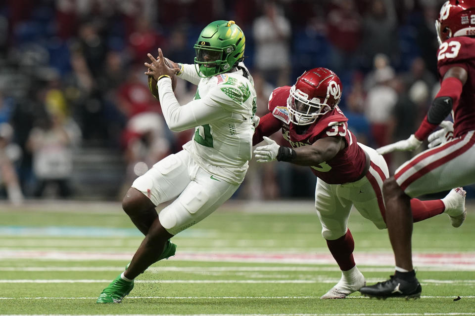 Oregon quarterback Anthony Brown (13) is sacked by Oklahoma linebacker Marcus Stripling (33) during the first half of the Alamo Bowl NCAA college football game Wednesday, Dec. 29, 2021, in San Antonio. (AP Photo/Eric Gay)