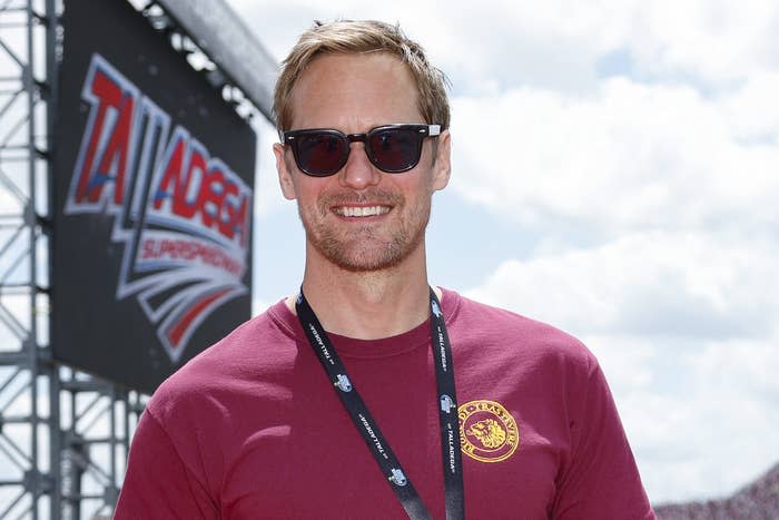 Alexander smiles while wearing a lanyard at an event