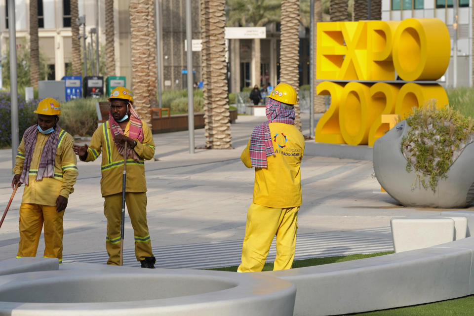 FILE - Workers clean an area at Expo 2020 in Dubai, United Arab Emirates, Oct. 3, 2021. Intent on making a flawless impression as the first host of the world’s fair in the Middle East, Dubai has spent over $7 billion on pristine fairgrounds and jubilant festivities. But propping up the elaborate fair is the United Arab Emirates’ contentious labor system that long has drawn accusations of mistreatment. (AP Photo/Jon Gambrell, File)