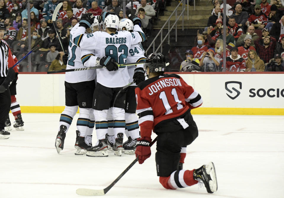 New Jersey Devils left wing Andreas Johnsson (11) reacts as the San Jose Sharks surround defenseman Erik Karlsson after his goal during the second period of an NHL hockey game Tuesday, Nov. 30, 2021, in Newark, N.J. (AP Photo/Bill Kostroun)