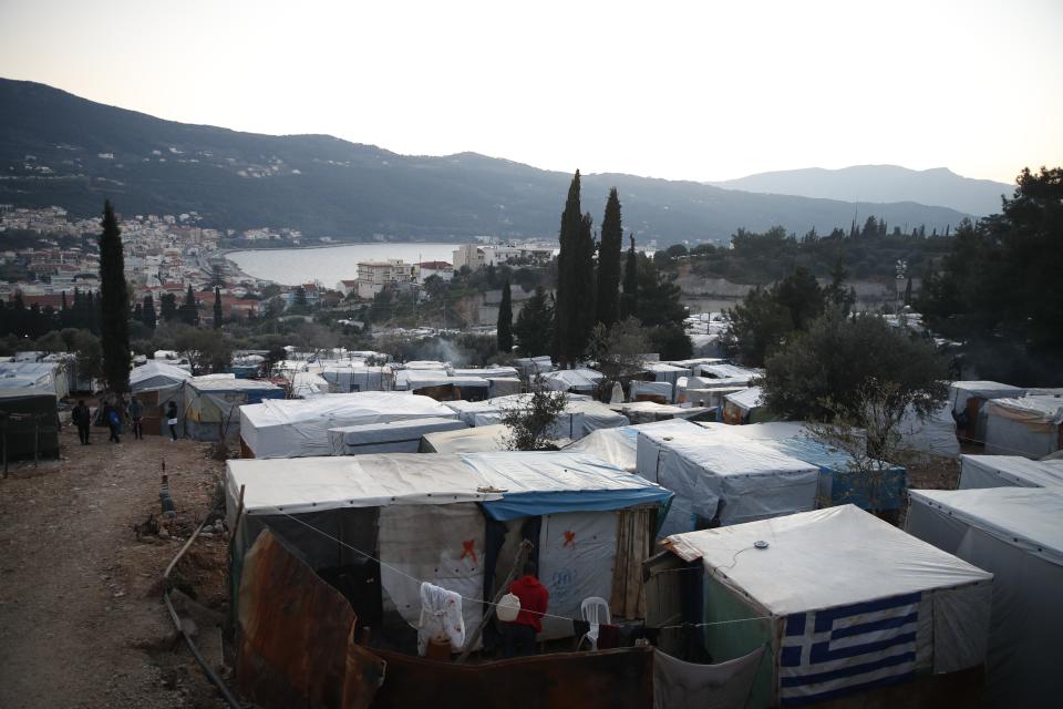 A Greek flag on a makeshift tent outside the perimeter of the overcrowded refugee camp at the port of Vathy on the eastern Aegean island of Samos, Greece, Tuesday, Feb. 23, 2021. On a hill above a small island village, the sparkling blue of the Aegean just visible through the pine trees, lies a boy’s grave. His first ever boat ride was to be his last - the sea claimed him before his sixth birthday. His 25-year-old father, like so many before him, had hoped for a better life in Europe, far from the violence of his native Afghanistan. But his dreams were dashed on the rocks of Samos, a picturesque Greek island almost touching the Turkish coast. Still devastated from losing his only child, the father has now found himself charged with a felony count of child endangerment. (AP Photo/Thanassis Stavrakis)