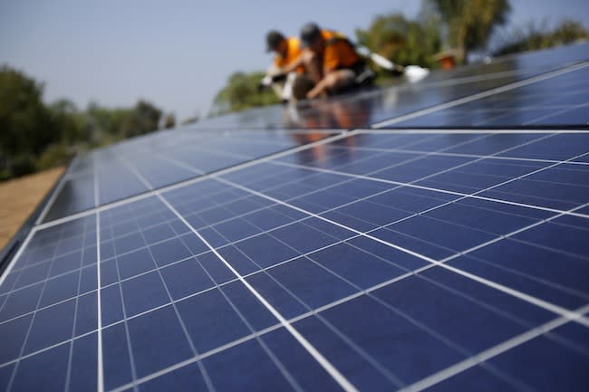 Technicians install solar panels on the roof of a house in Mission Viejo, California, in October. (Reuters/Mario Anzuoni)