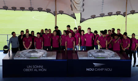 Barcelona's soccer team pose with a model of the project to reform the Camp Nou stadium in Barcelona, Spain, April 21, 2016. REUTERS/Albert Gea