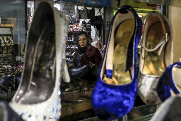 A woman looks at a shop window in the northeastern Syrian town of Qamishli on May 2, 2018