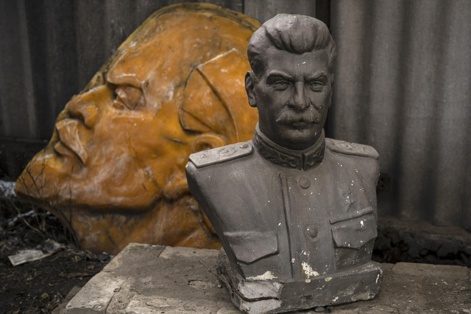 Discarded communist era statues depicting Stalin, front, and Lenin lay on the ground outside a glass workshop in Kharkiv, Ukraine, Tuesday, Feb. 28, 2023. (AP Photo/Vadim Ghirda)