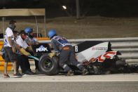 Haas driver Romain Grosjean of France has his car taken after a crash during the Formula One race in Bahrain International Circuit in Sakhir, Bahrain, Sunday, Nov. 29, 2020. (Hamad Mohammed, Pool via AP)