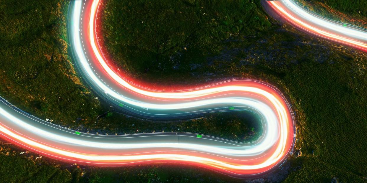 directly above view by drone of stunning colorful light trails in curvy road