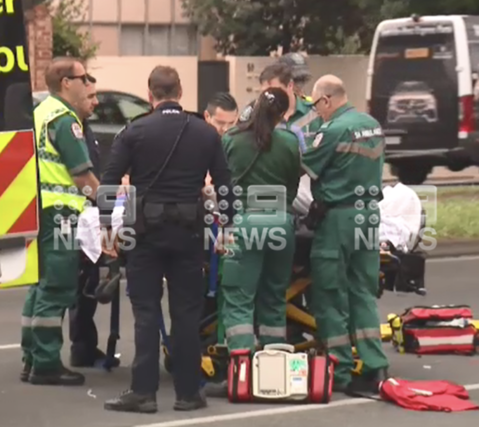 paramedics are seen tending to the police officer at the scene. 