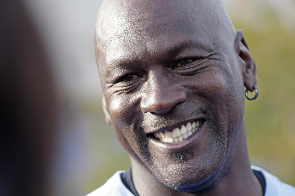 Charlotte Hornets owner Michael Jordan smiles as he greets people and hands out food for Thanksgiving to members of the community in Wilmington, N.C., Tuesday, Nov. 20, 2018. (AP Photo/Gerry Broome)