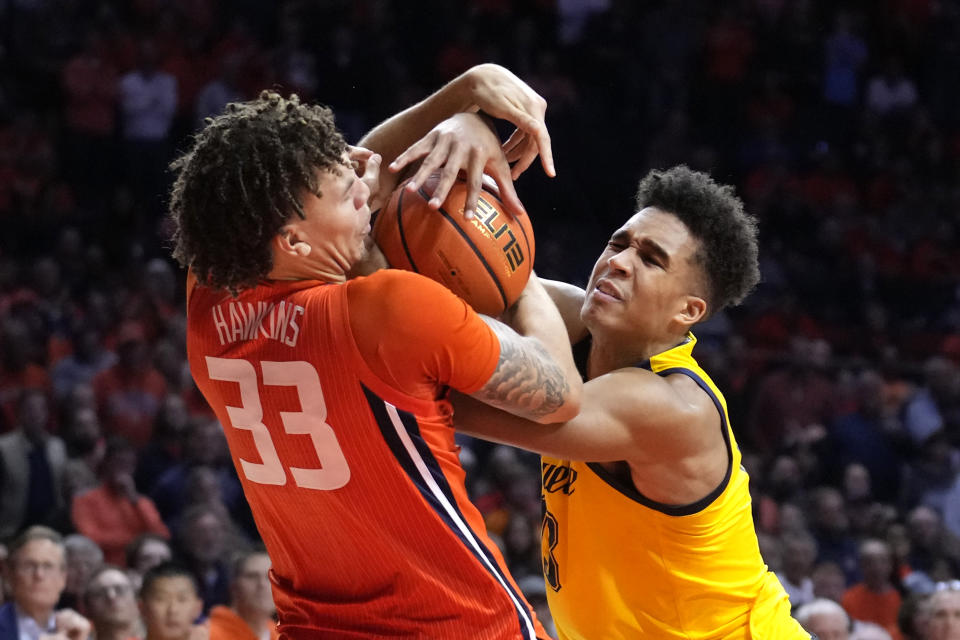 Illinois forward Coleman Hawkins (33) fouls Marquette forward Oso Ighodaro as he tries to wrestle the ball from Ighodaro during the second half of an NCAA college basketball game Tuesday, Nov. 14, 2023, in Champaign, Ill. (AP Photo/Charles Rex Arbogast)