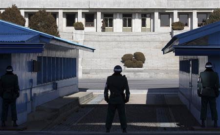 A North Korean soldier (top L) keeps watch as South Korean soldiers stand guard at the truce village of Panmunjom in the demilitarised zone separating the two Koreas, north of Seoul February 6, 2014. REUTERS/Han Jae-ho/News1