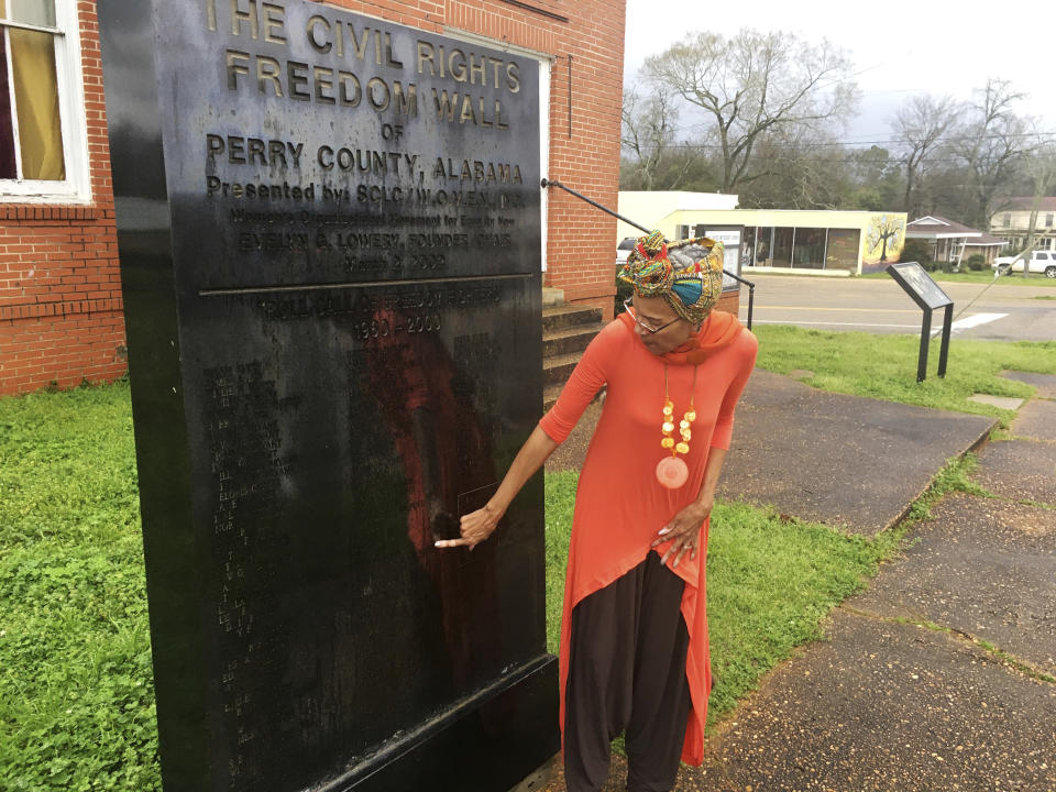 In this Feb. 18, 2020, photo, Della Simpson Maynor finds her name and her siblings names on a monument erected for people who marched and fought for voting rights in Marion, Ala. Maynor remembers the mounted police officer cracking her elbow with a baton. She recalls the panicked marchers unable to escape the onslaught, and the scuffle between officers and a young church deacon who was trying to protect his mother and grandfather. (AP Photo/Gary Fields)